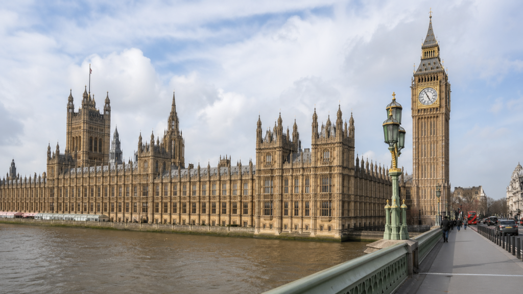 The Palace of Westminster in London on a clear day, representing the legislative process behind the Grenfell Tower Memorial Bill.
