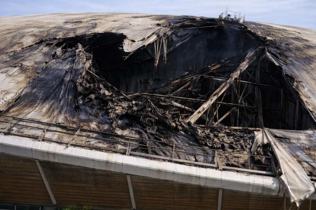 Close-up of damaged lightweight roof membrane on a large public sports building after fire exposure