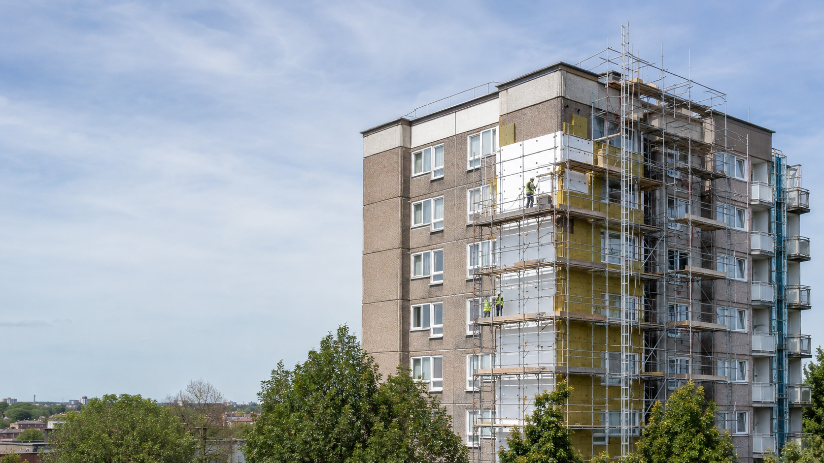 A realistic UK residential block undergoing remediation work, with scaffolding around parts of the building and a clean city skyline in the background.